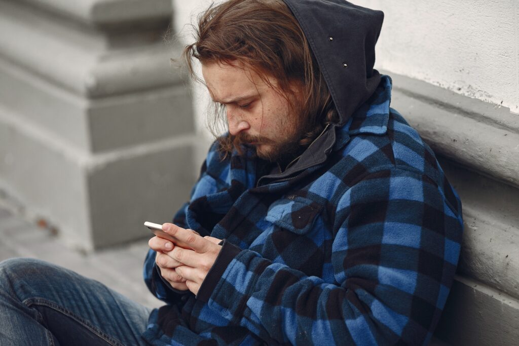 A homeless man using a mobile device